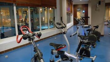 Un gimnasio con bicicletas estáticas, una cinta de correr y equipo de ejercicio.