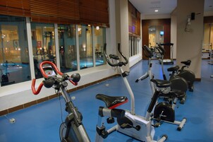 Un gimnasio con bicicletas estáticas, una cinta de correr y equipo de ejercicio.
