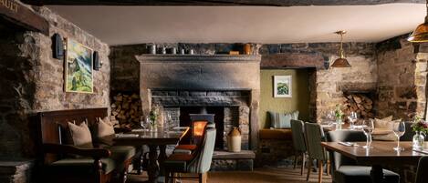 Un interior rústico con chimenea de piedra, muebles de madera y una zona de estar acogedora.
