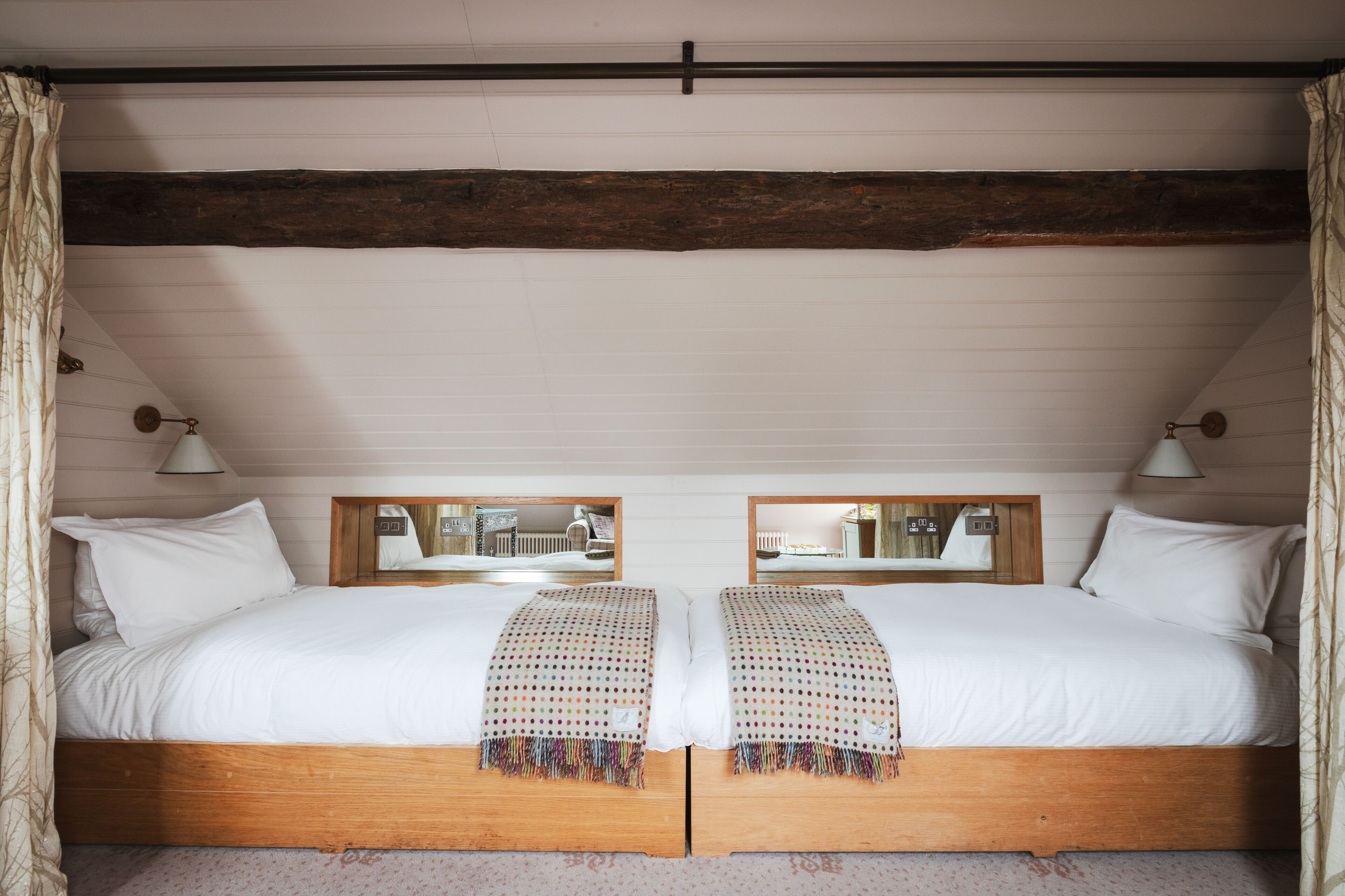 Una cama doble con estructura de madera y un espejo encima.