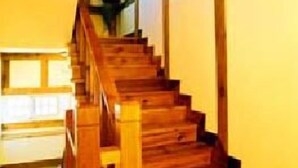 Un escalier en bois, doté d’une rampe, menant à l’étage supérieur.