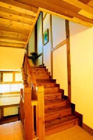 A wooden staircase with a handrail, leading to an upper floor.