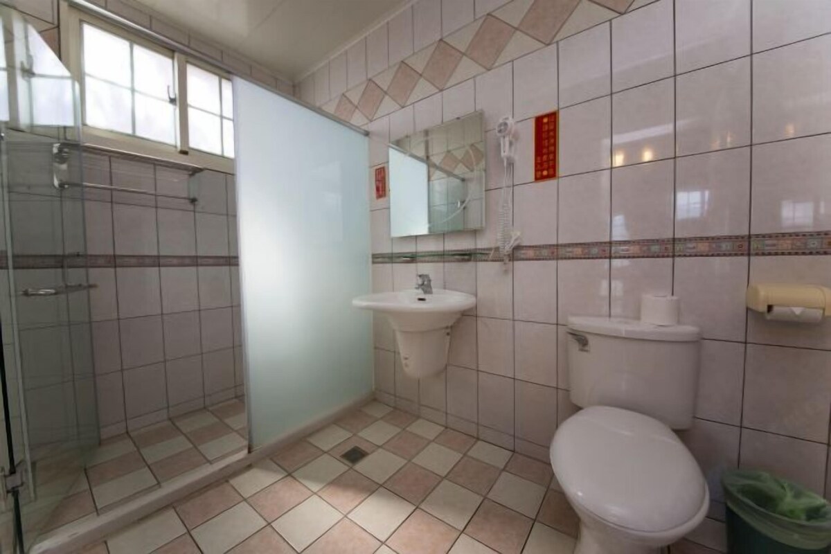 Un baño con cabina de ducha de vidrio, lavamanos, inodoro y espejo.