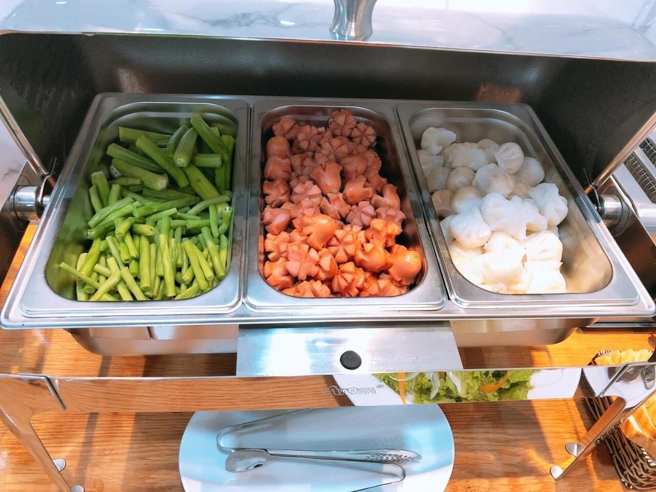 A buffet with three food containers: green beans, diced tomatoes, and shrimp.
