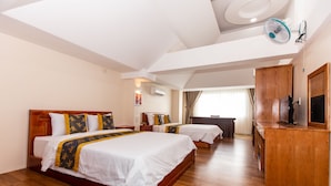 A hotel room with two beds, wooden flooring, a ceiling fan, a TV, and a desk. - Hoa De Nhat Hotel (Ho Chi Minh City)