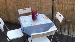 A table set for four with a blue tablecloth, white chairs, and a purple menu. - Elite Loreto Milano (Milan)