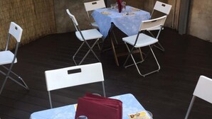 A round table with a blue tablecloth, surrounded by white folding chairs. - Elite Loreto Milano (Milan)