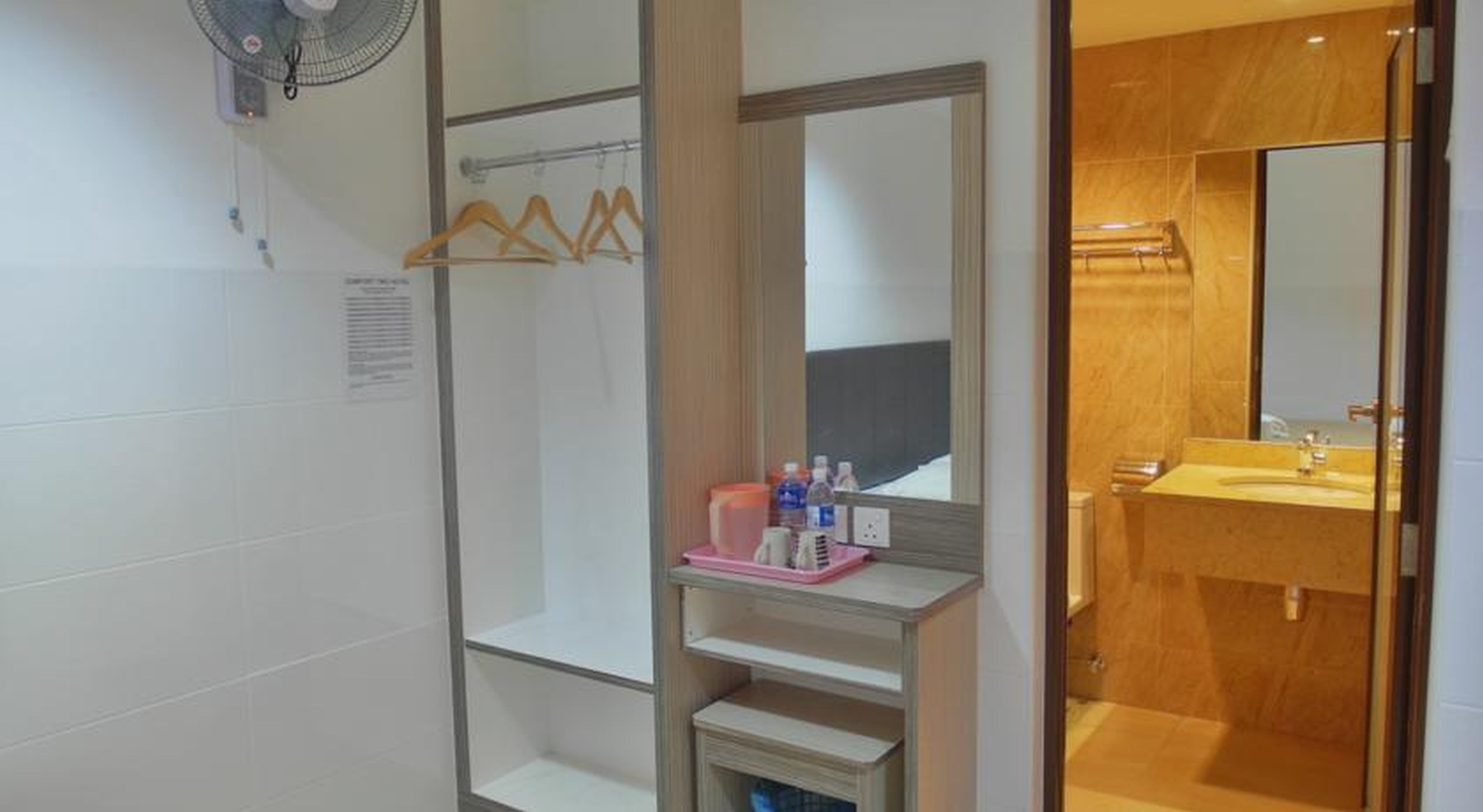 A bathroom with a shower, a sink, and a mirror. There are toiletries on the sink counter.