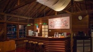 A rustic coffee bar with wooden beams, a large menu board, and bar stools. - D' Agape Meeting & Conference (Megamendung)