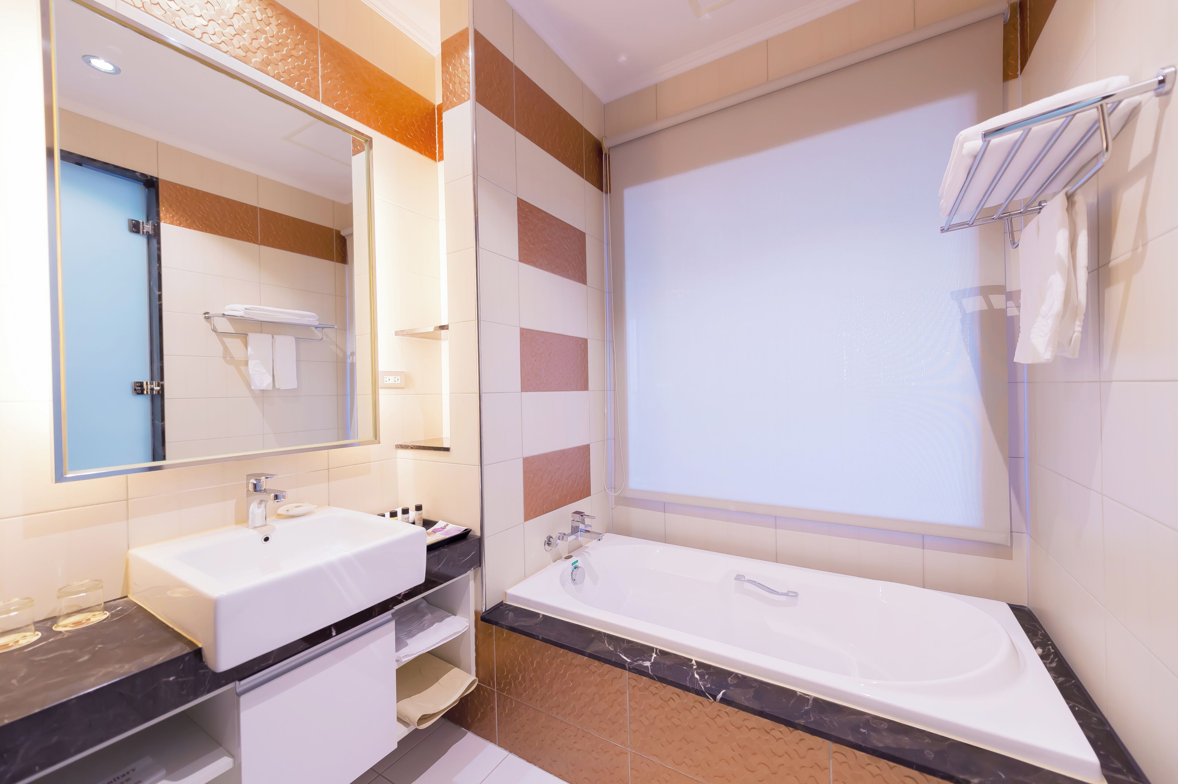 A modern bathroom with a large bathtub, a vanity with a sink, and a mirror.