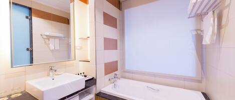 A modern bathroom with a large bathtub, a vanity with a sink, and a mirror.