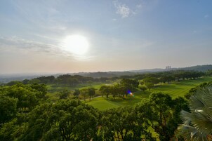 Campo de golf bajo un cielo despejado y luz solar.