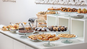 Un bufé con diversos productos de pastelería y bollería.