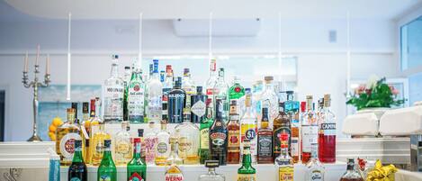 Zona de bar con una variedad de botellas de licores a la vista.