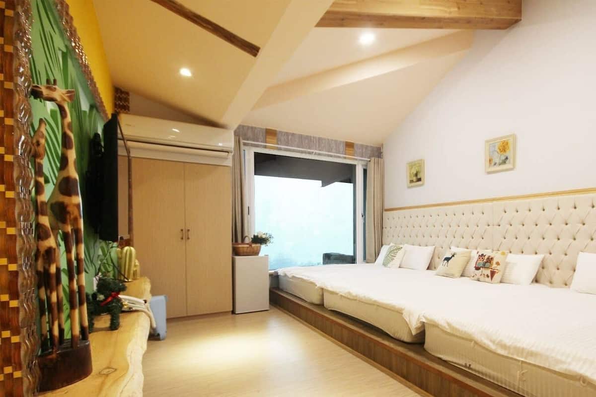 A bedroom with a large bed, a wardrobe, and a window.