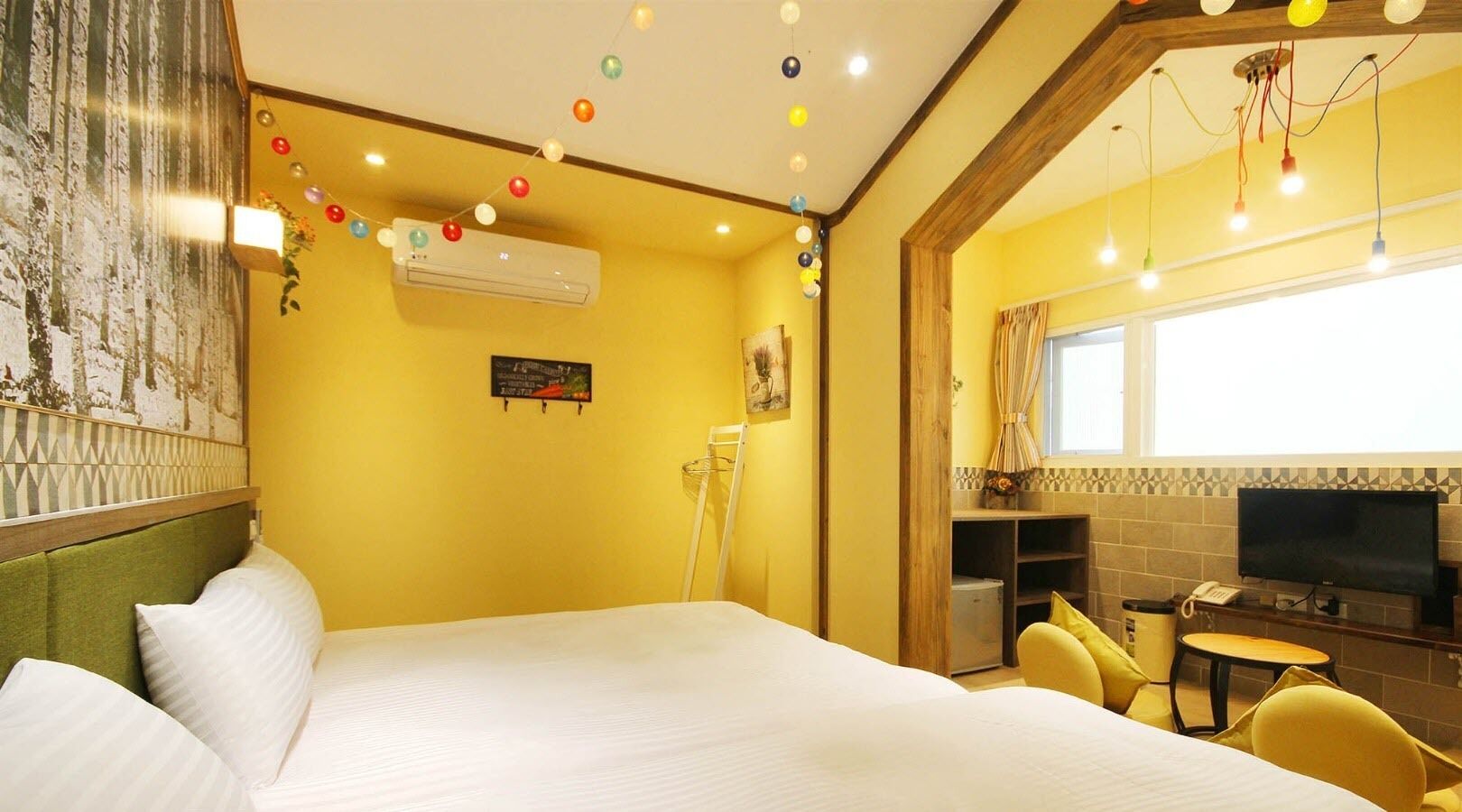A hotel room with a large bed, a desk with a chair, a television, and a window.