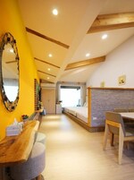 Un dormitorio moderno con techo de madera, una cama, un escritorio y una silla.
