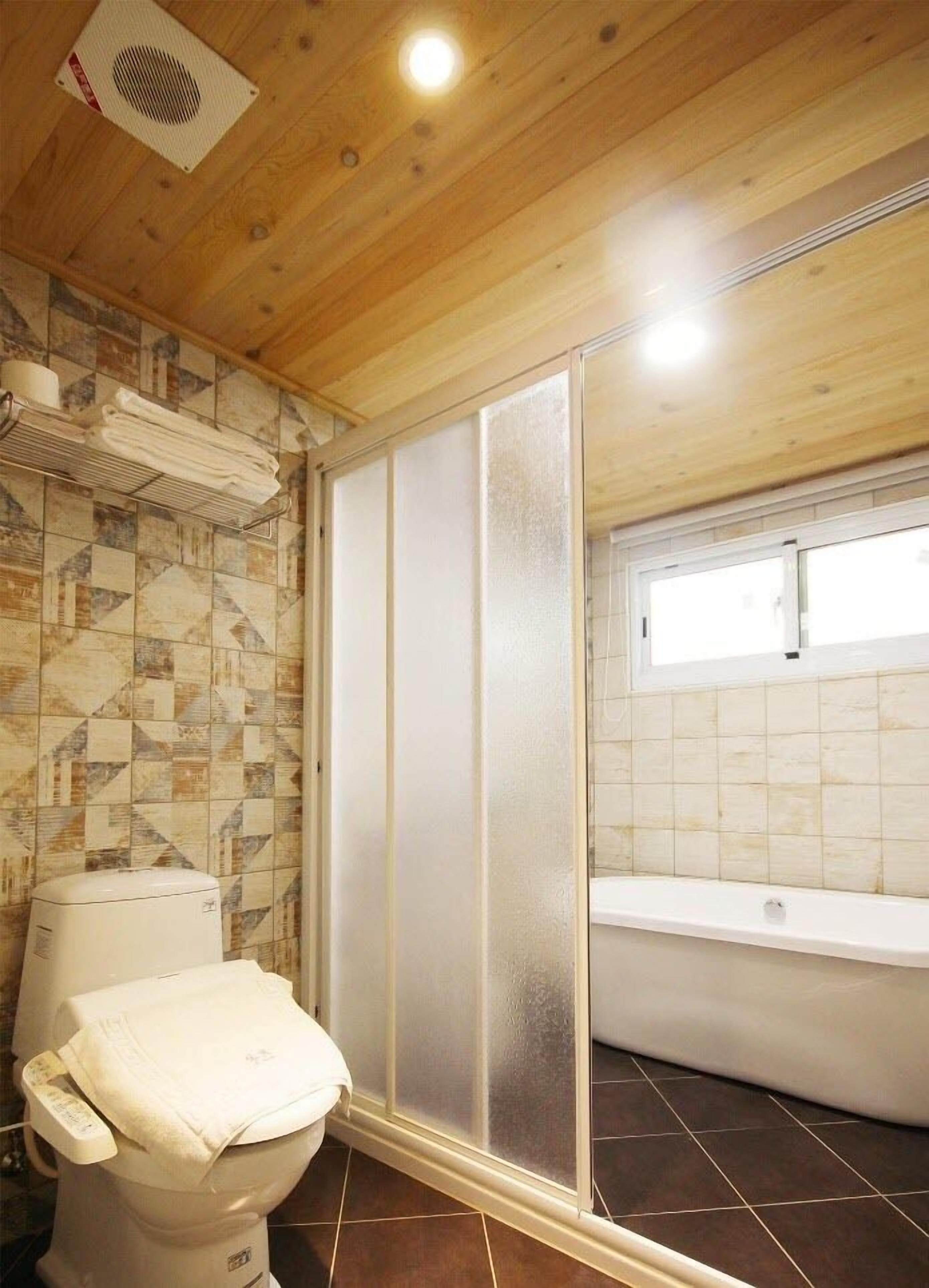 A bathroom with a toilet, a shower enclosure, and a bathtub.