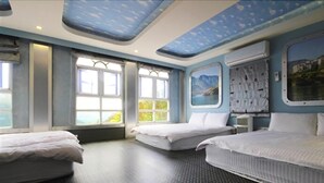 Ein Zimmer mit zwei Betten, großen Fenstern und Blick auf Grünfläche.