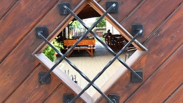 Eine Holzkonstruktion mit einem diamantförmigen Fenster und Metallstreben.