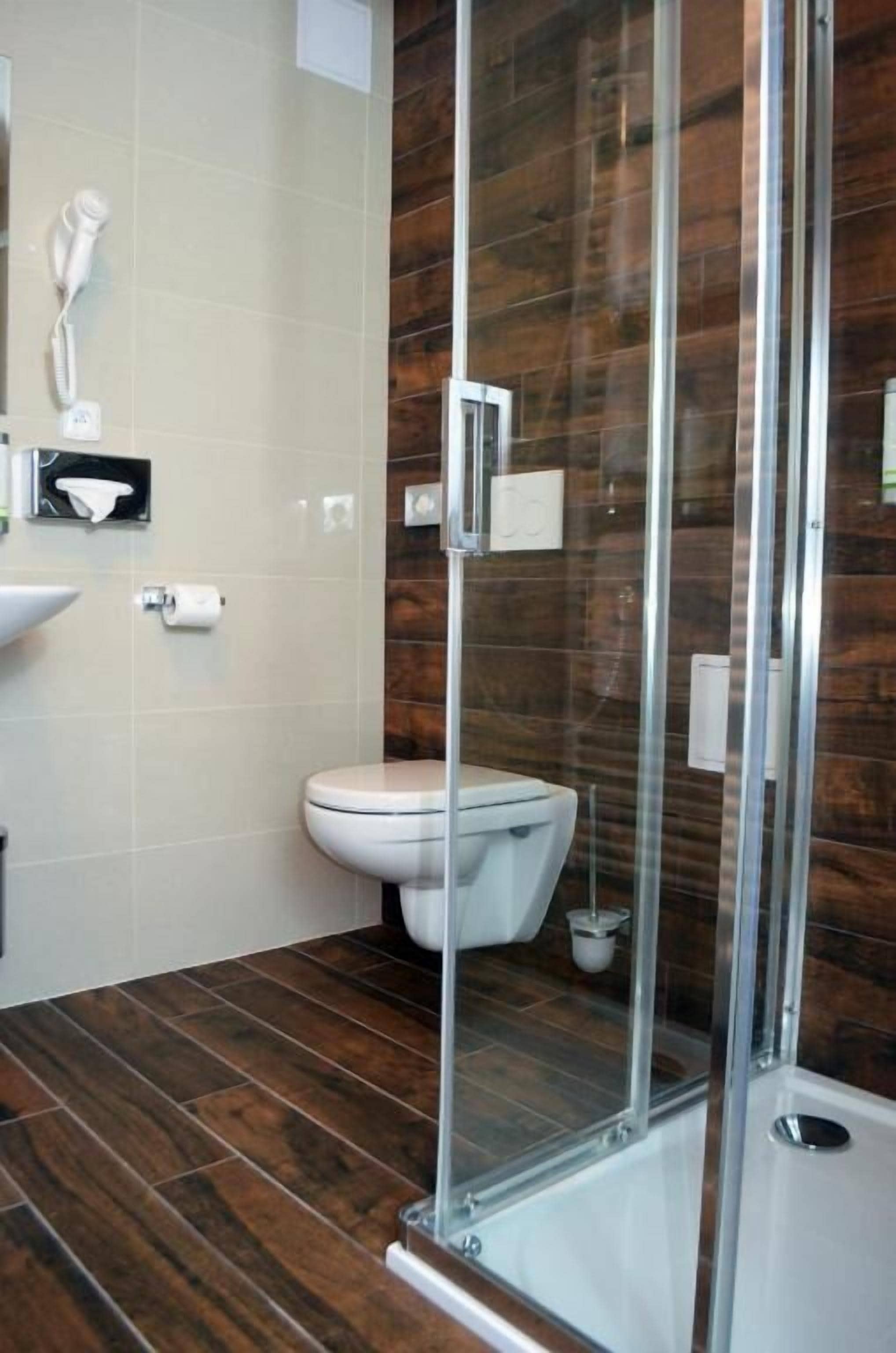 Une salle de bain moderne avec une douche à parois de verre, des toilettes et un lavabo.
