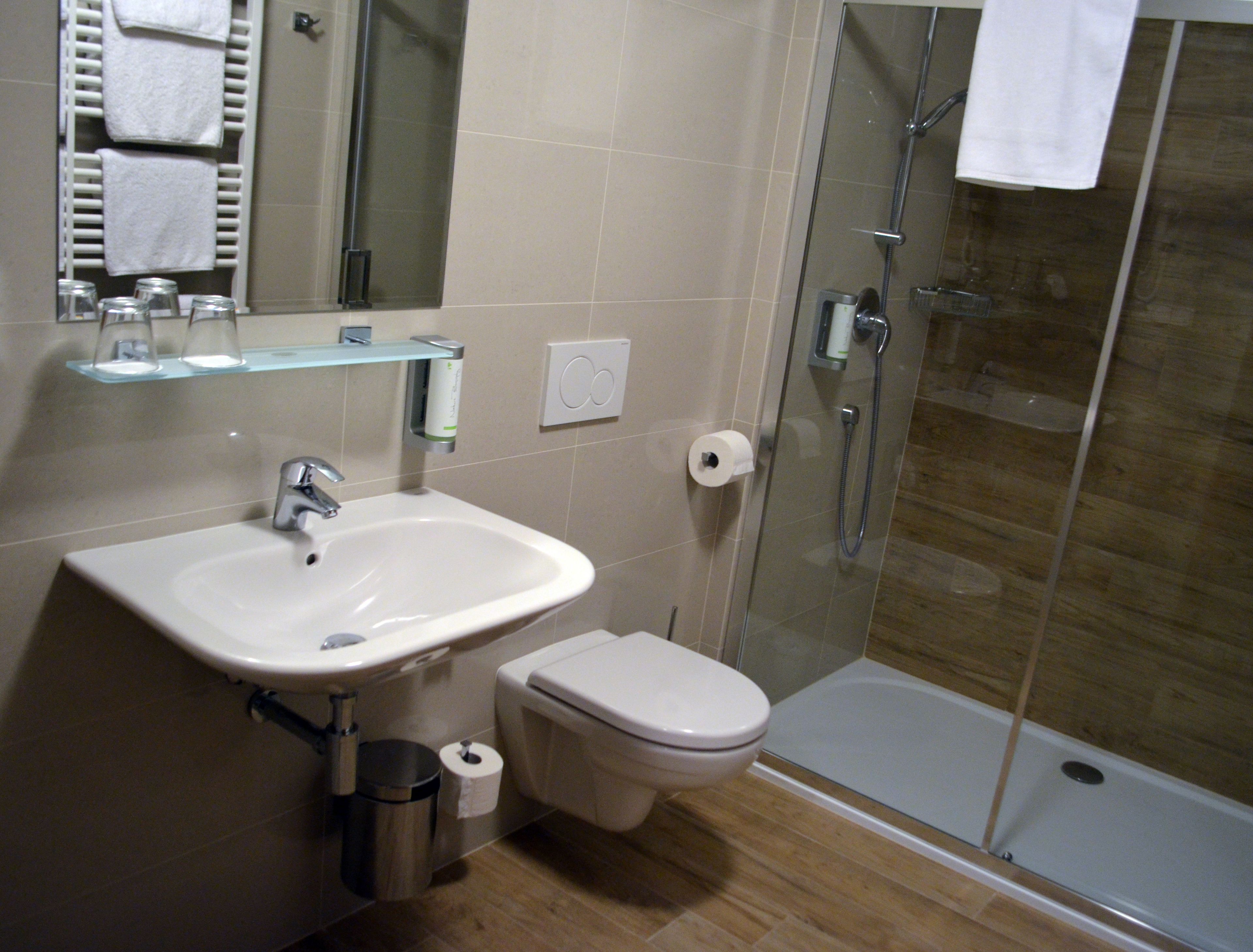 Et badeværelse med vask, toilet og brusekabine.