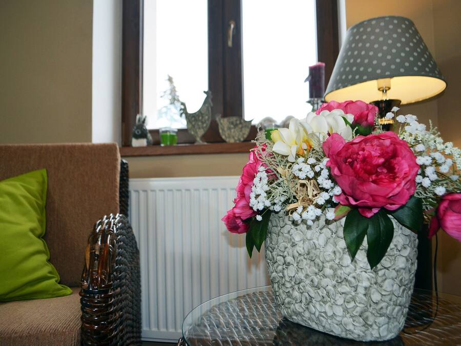 En stue med en sofa, en lampe og en blomstervase.