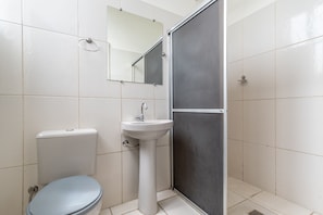 A bathroom with a toilet, sink, and shower enclosure. - Hotel L'espace - Jaragua Belo Horizonte (Belo Horizonte)