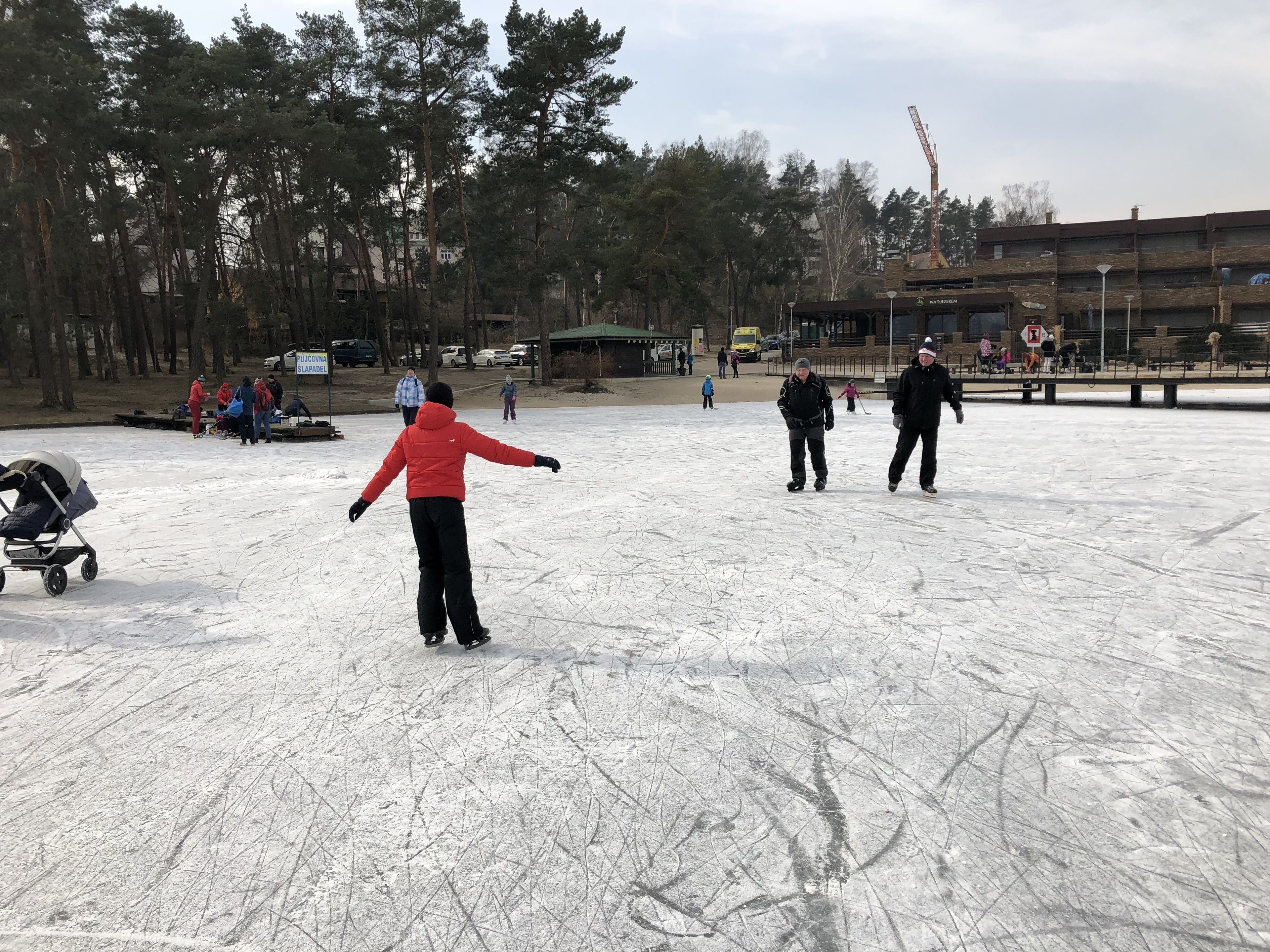 A snowy outdoor area with people ice skating.