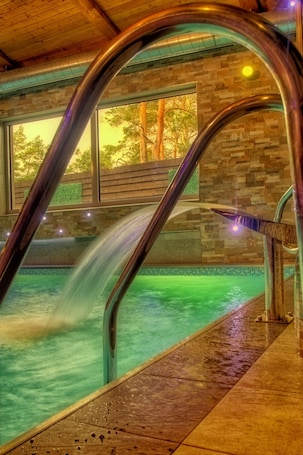 Una piscina techada, sillones reclinables de piscina