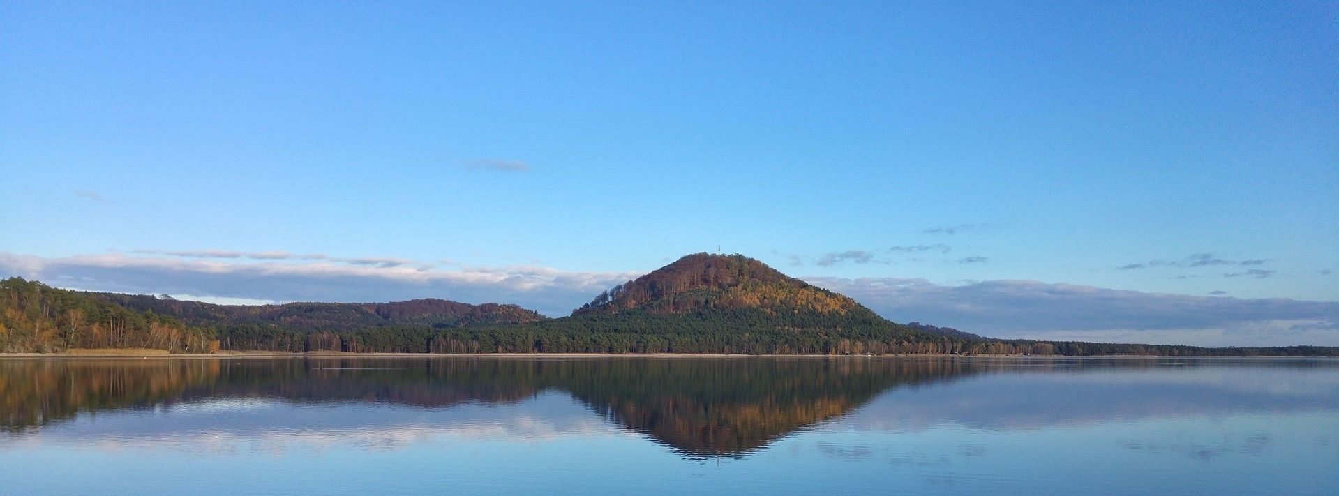 A calm lake with a mountain in the background.