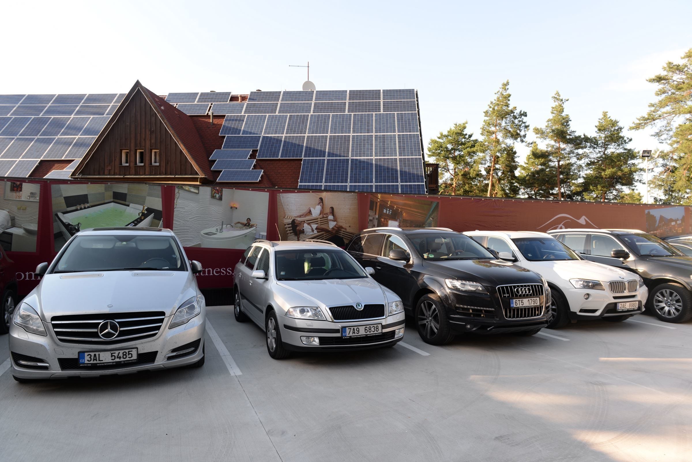 A parking lot with several cars, including a white Mercedes-Benz and a silver sedan.