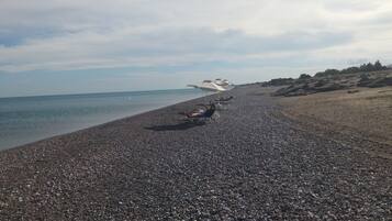 En la playa, camastros y sombrillas