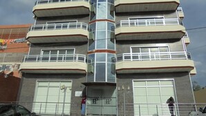 A multi-story building with a 'HOTEL' sign on the top left and a 'PACIFIC' sign on the top right. - Hotel Pacific (Nacala)