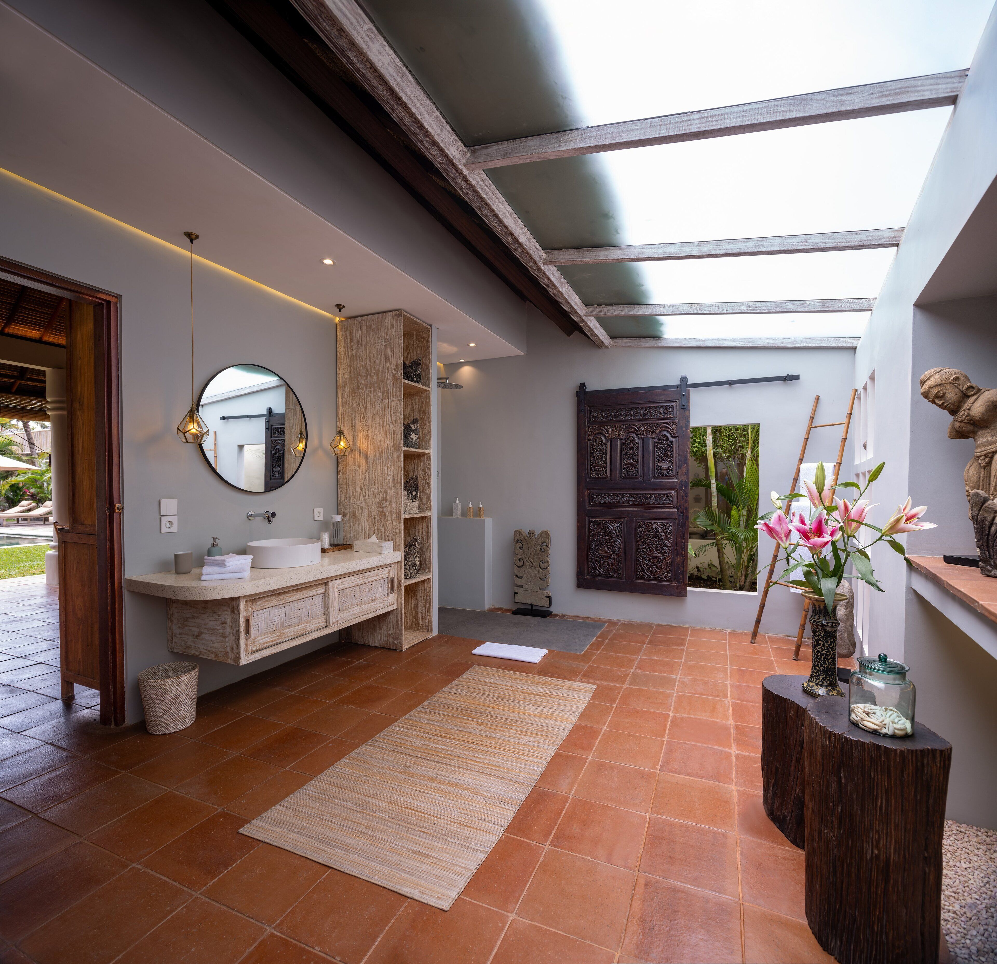 Casa de banho moderna com um espelho grande, toucador de madeira e lavatório de pedra.