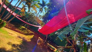 Una hamaca tensada entre árboles en un paisaje tropical.