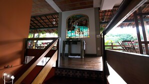 Una escalera conduce a una habitación con un ventanal de vitral, techo de madera y vistas al exterior.