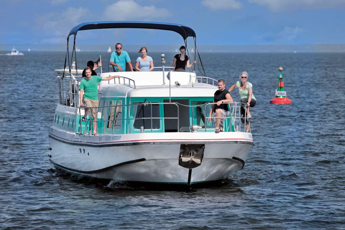 A boat with passengers, a clear sky, and calm water.
