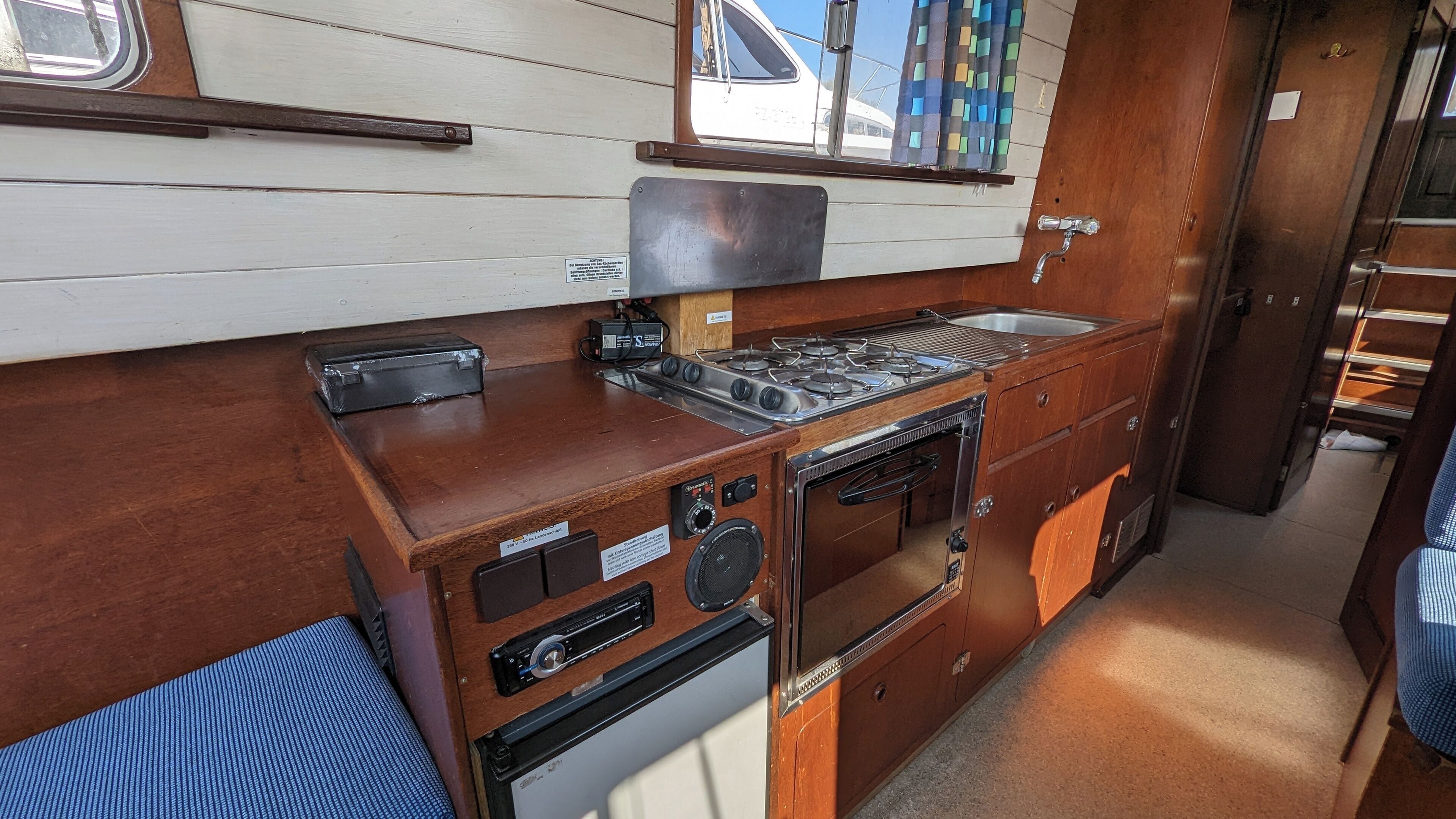 Cocina compacta con estufa a gas, horno y lavaplatos.