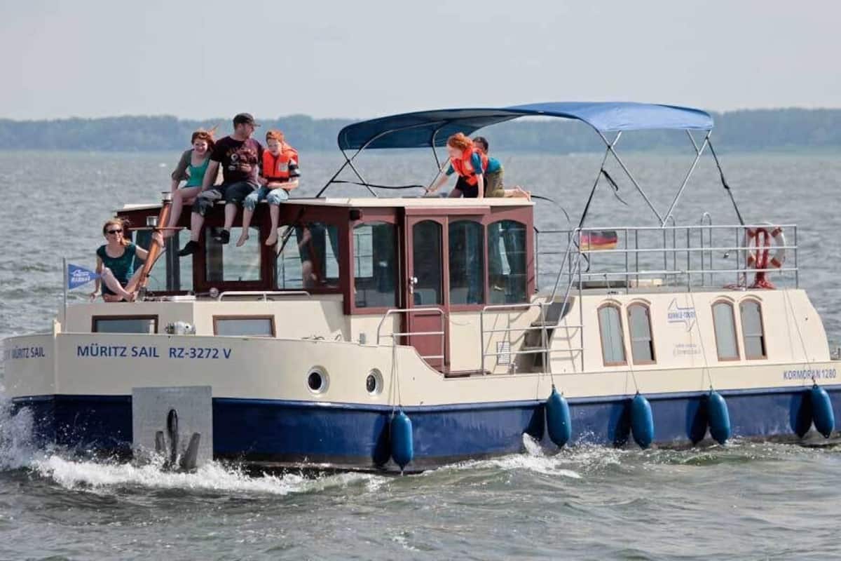 A boat with passengers, a cabin, and a blue canopy.