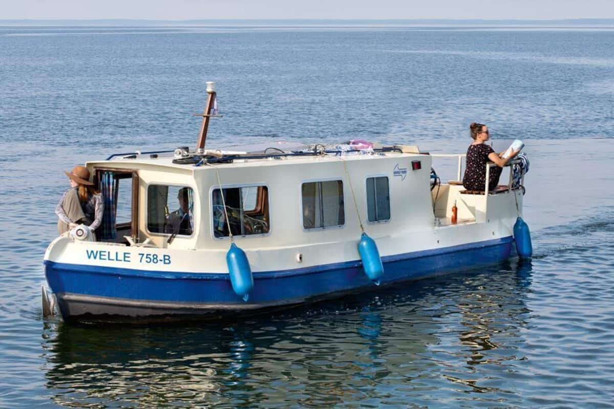A small boat named WELLE 758-B on calm water.