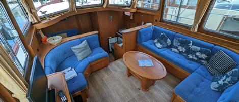 A cozy interior with a curved wooden bench seating area, a small wooden table, and a television.