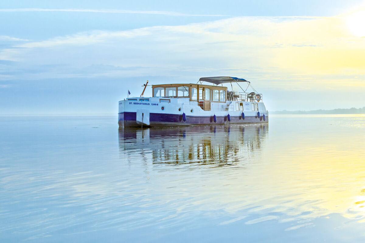 A stationary boat with a cabin structure and a covered deck area.