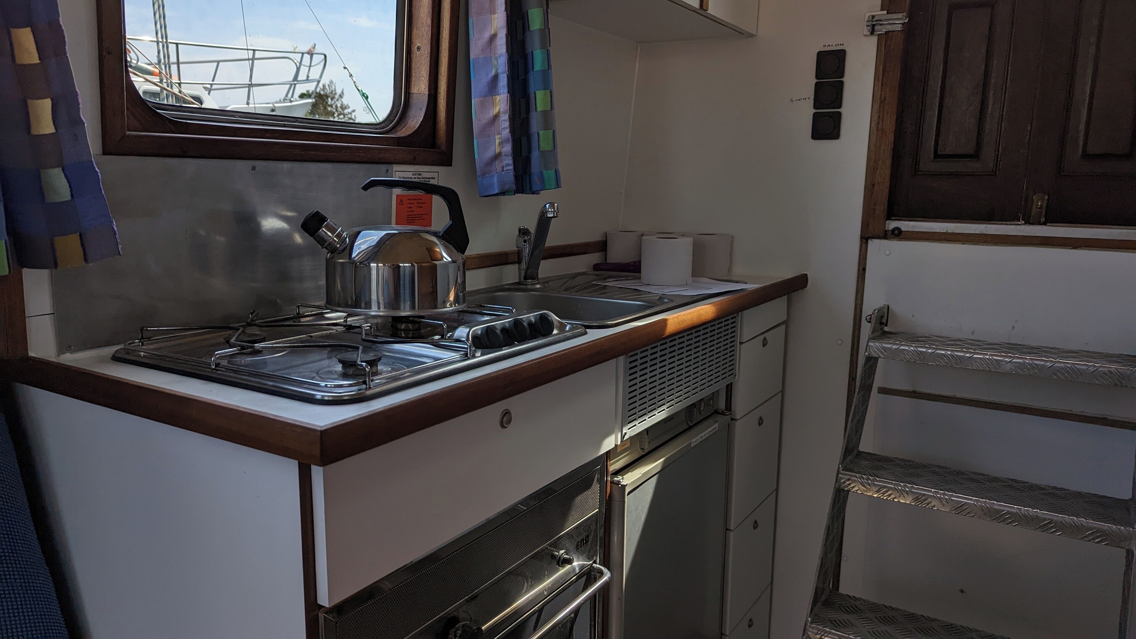 Una kitchenette compacta con estufa, lavamanos y un refrigerador pequeño.