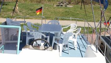 Enjoy al fresco dining on the boat's spacious deck, complete with a shaded table and chairs.
