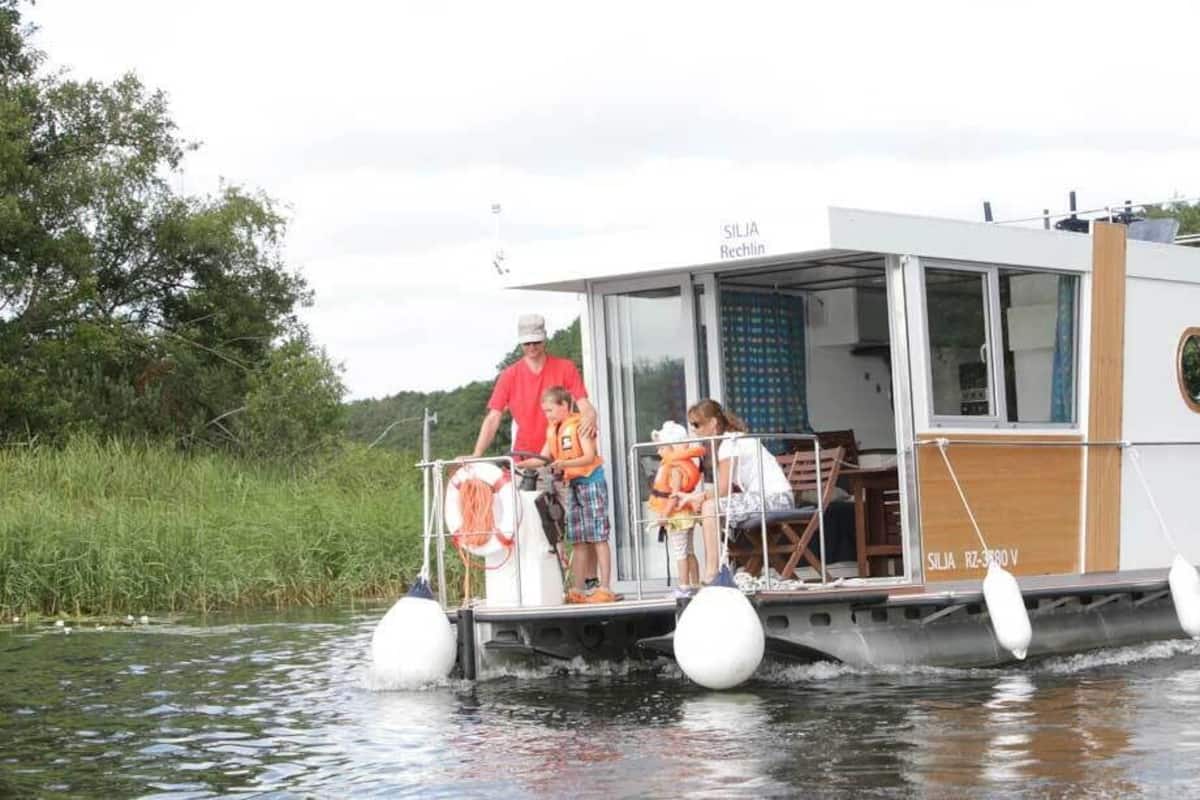 A riverboat with a covered deck, a dining area, and a cabin with a glass door.
