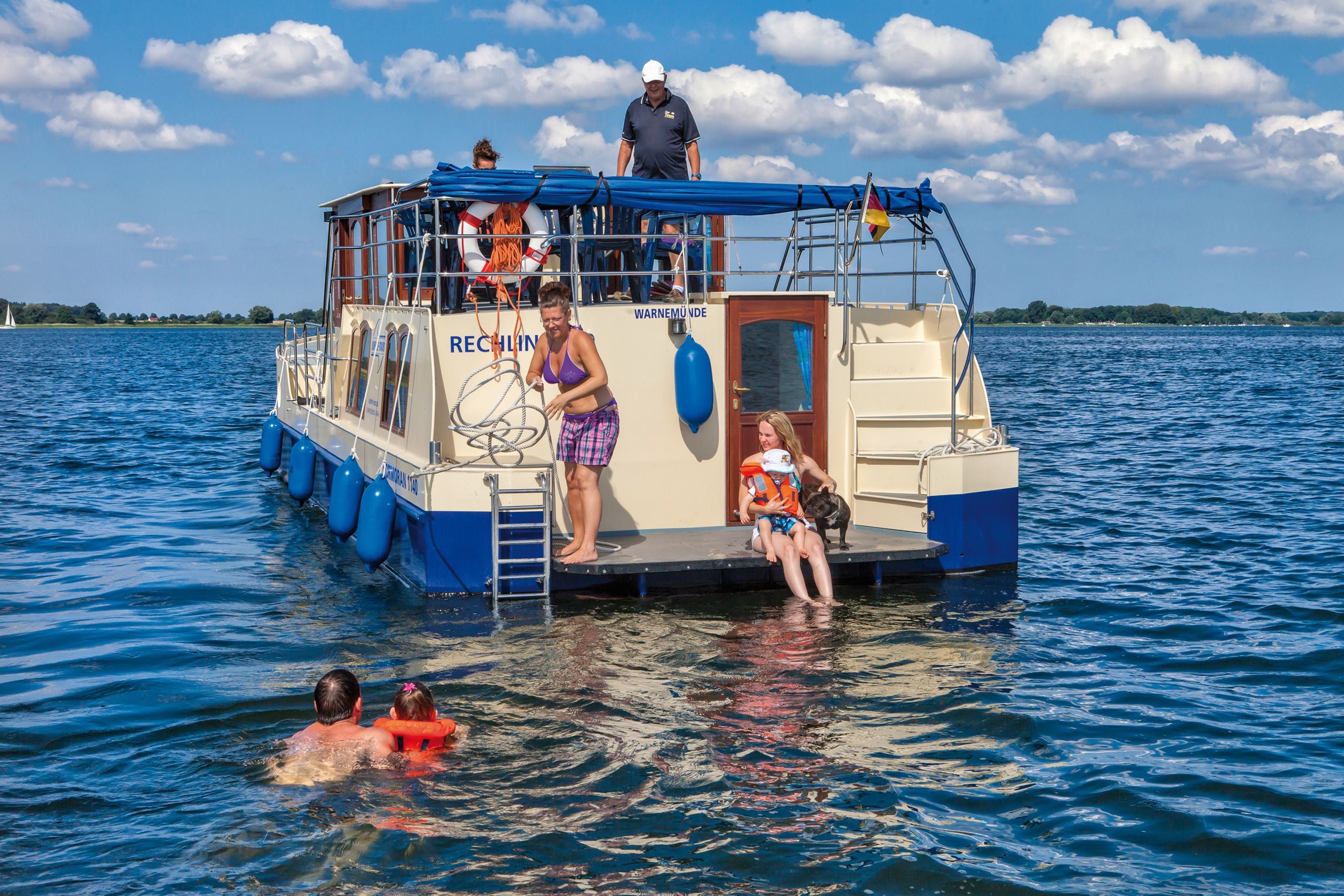 Un bote con cubierta y una pequeña cabina, flotando en el agua.