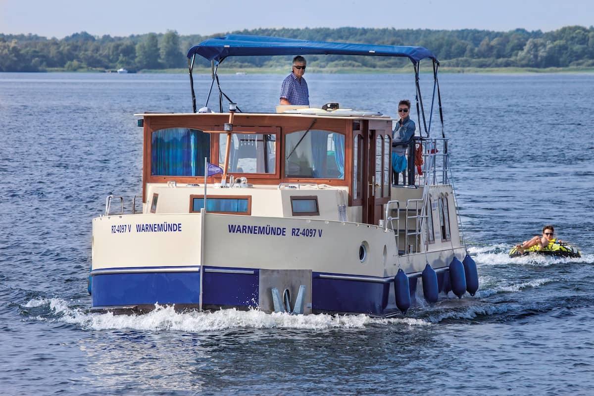 A boat with a cabin and a covered area, named 'WARNEMÜNDE'.