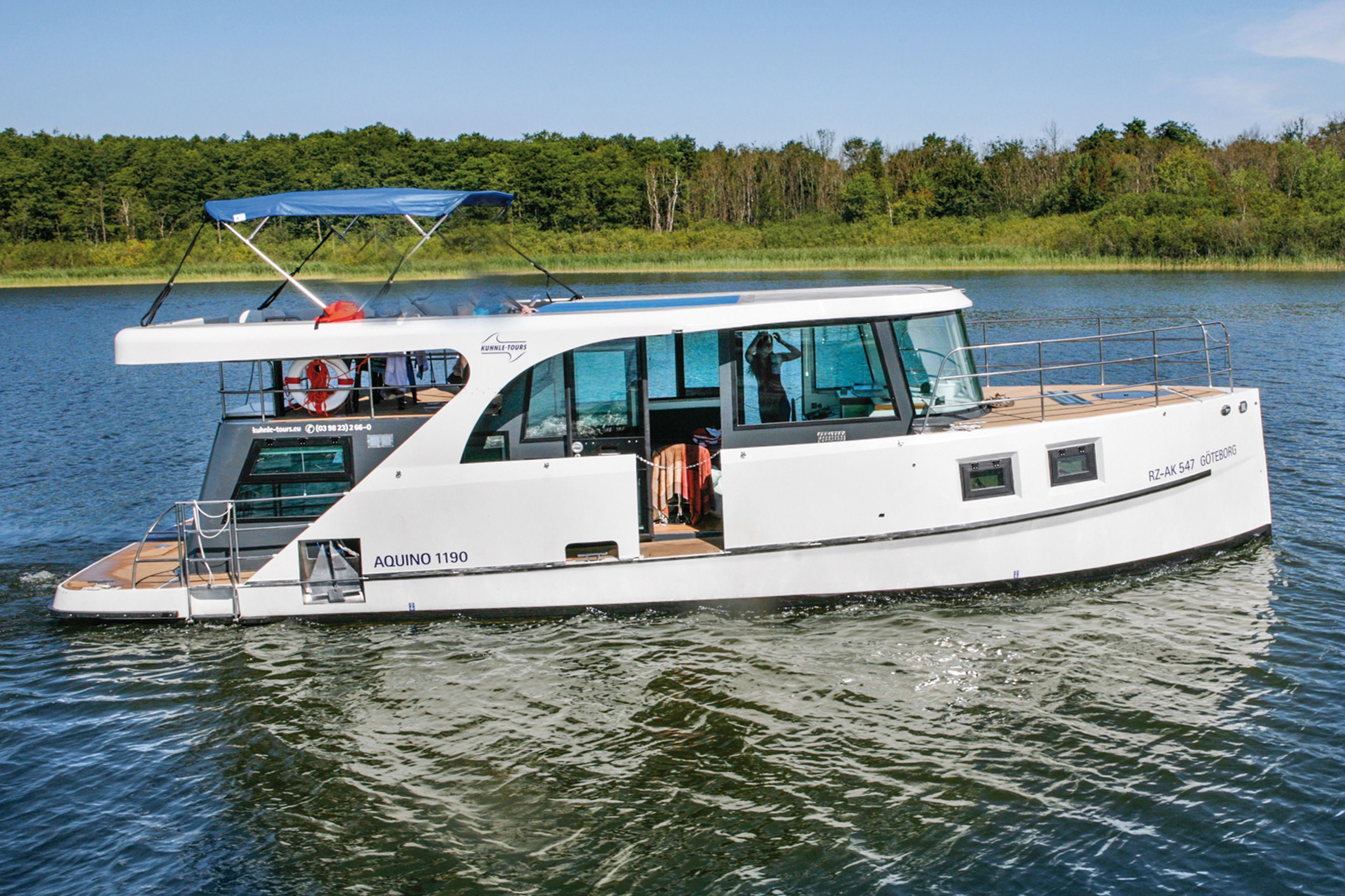 A white motorboat with a covered deck, windows, and a life preserver.