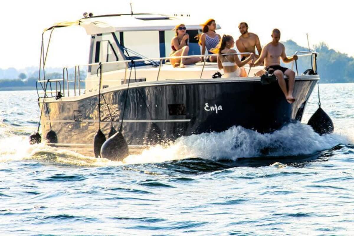 A boat with the name "Enja" on its side, moving through a body of water.